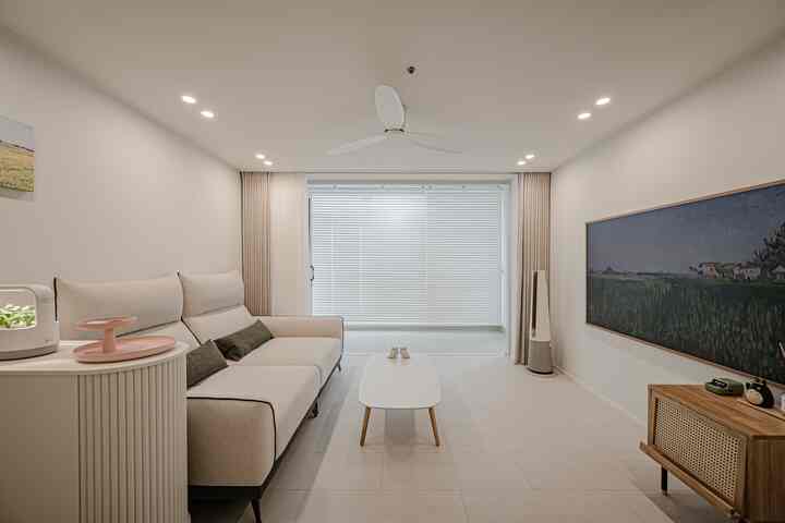 ホワイトとベージュのリビングルーム、大きな窓とカーテン、ミニマルなソファとコーヒーテーブルが配置された印象的な空間