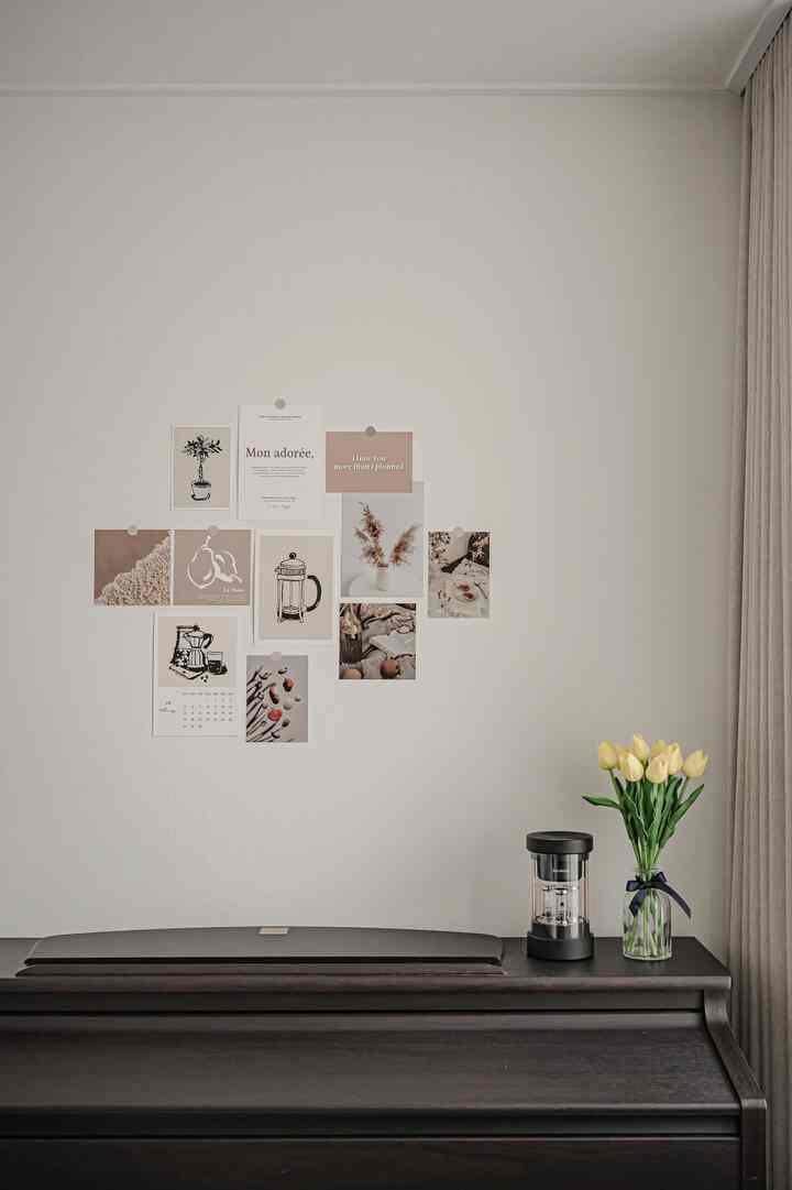 Beige-toned bedroom master room featuring a dark brown piano topped with yellow tulip flowers and a black speaker in a simple modern space