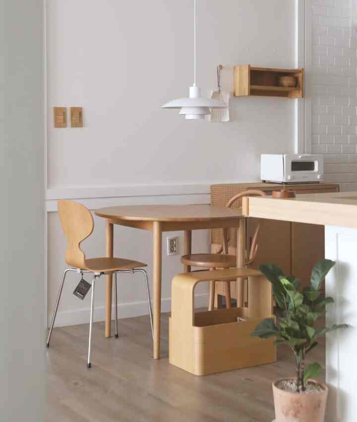 Natural wood tone kids' room featuring a round table and pendant light with cozy atmosphere