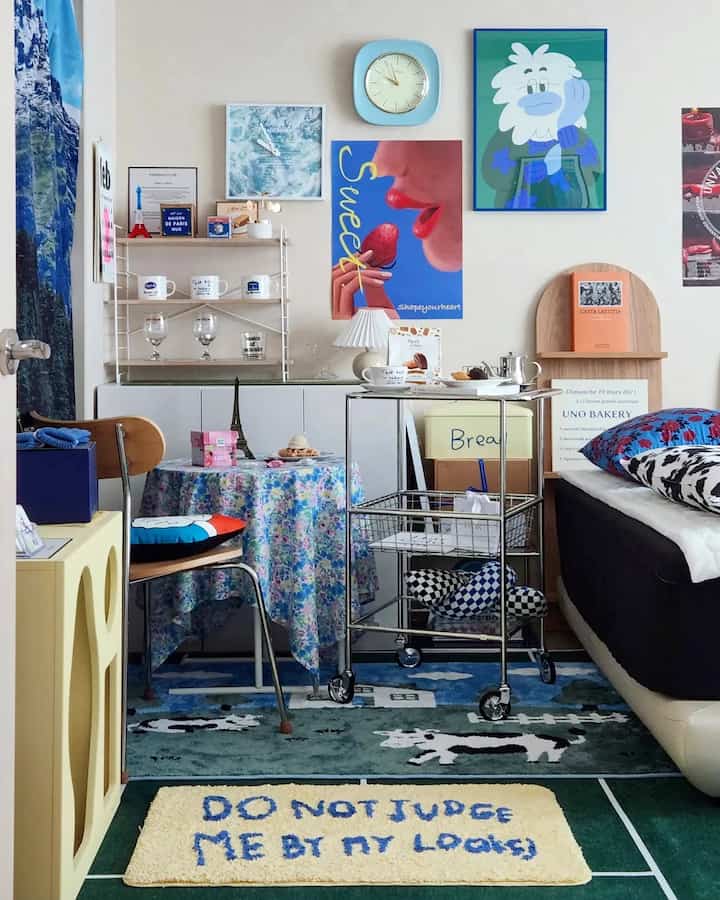 Blue and wood tone bedroom featuring a modular trolley, floor rugs, and fabric curtain with charming decor