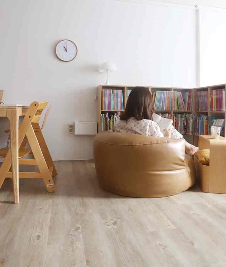 ナチュラルウッドトーンのリビング書斎、ブラウンのレザービーンズクッションが配置された落ち着いた雰囲気の空間