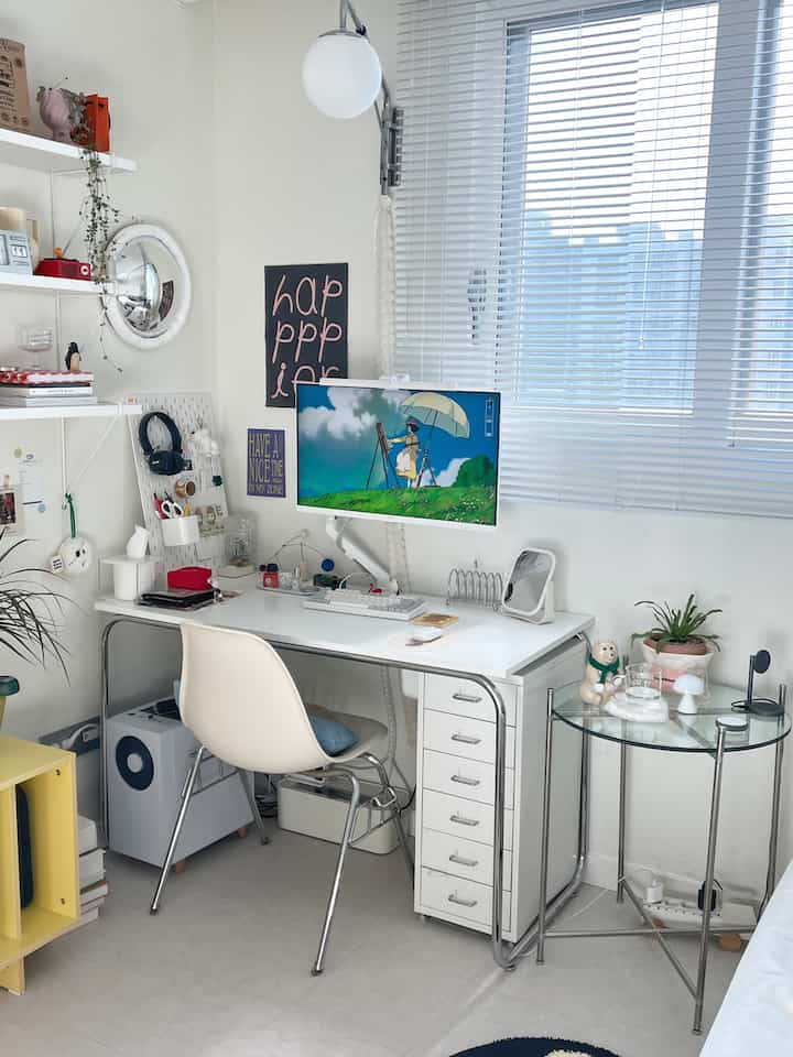 Bright white-toned compact home office with a white desk, chair, and blinds featuring modern interior design