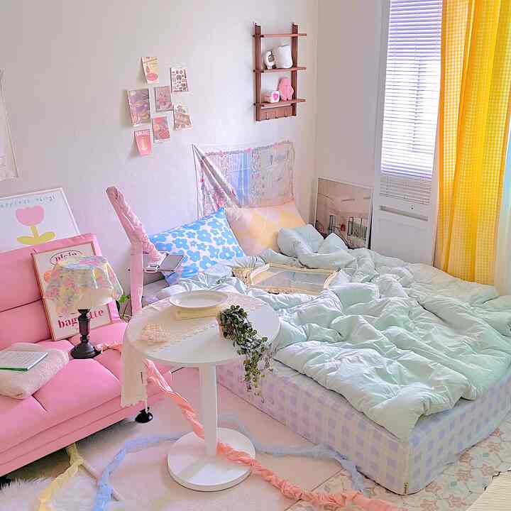 Pastel-toned compact bedroom featuring a pink sofa, yellow gingham curtains, and a white round table creating a cozy atmosphere