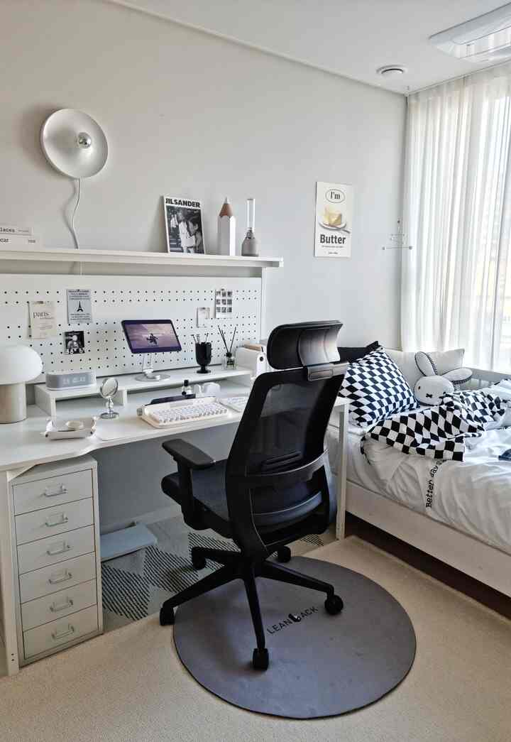 White-toned bedroom featuring black mesh office chair and desk creating a clean home office setup