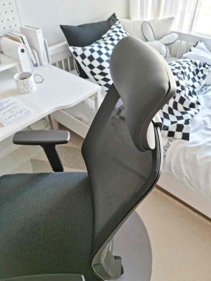 Black and white toned home office bedroom featuring an office chair and desk in a neat space