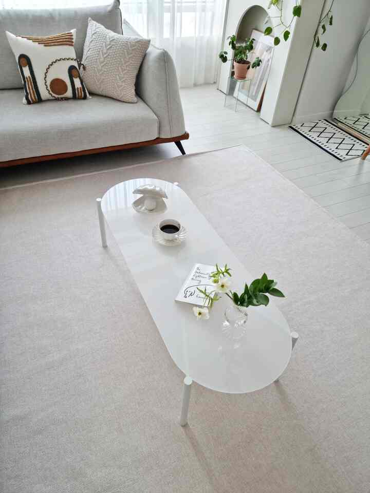 Bright and clean living room in white and beige tones featuring a simple sofa and coffee table