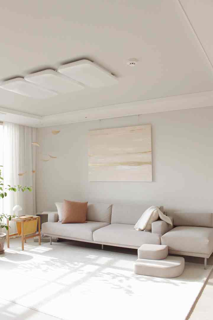 A natural modern living room with soft beige sofa and white rug bathed in natural sunlight