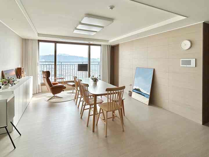 Bright, natural-tone living room in white and brown featuring dining table and recliner designed for conversation focus