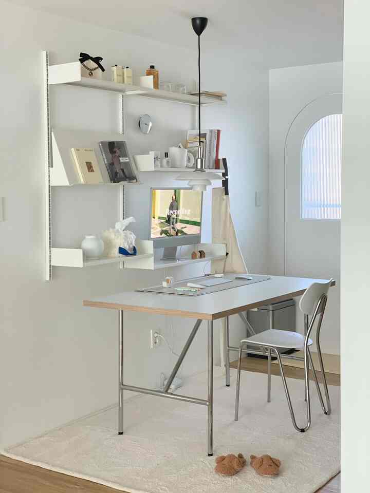 White-toned kitchen and home office space featuring Rarelo shelves and a minimalist desk in a modern interior