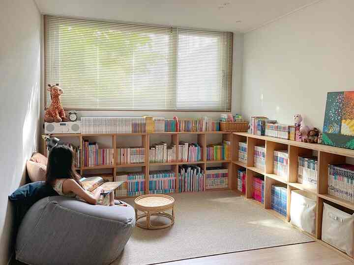 ベージュと木目調の調和が取れた子供部屋、本棚とビーズクッションが配置された居心地の良い読書スペース