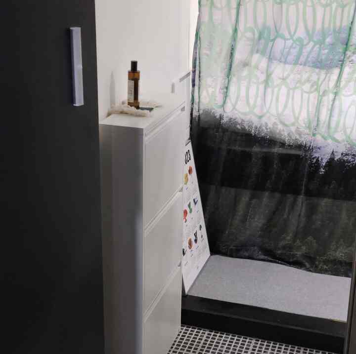 白色調の狭い玄関、スリムなシューズラックとシアーカーテンで空間を仕切った機能的なインテリア