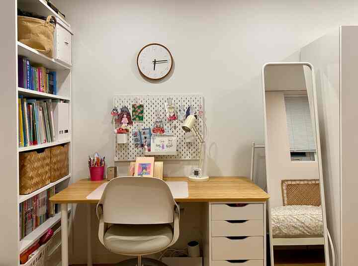 White and wood tone kids' room featuring a desk, bookshelf, and full-length mirror with a neat study area atmosphere