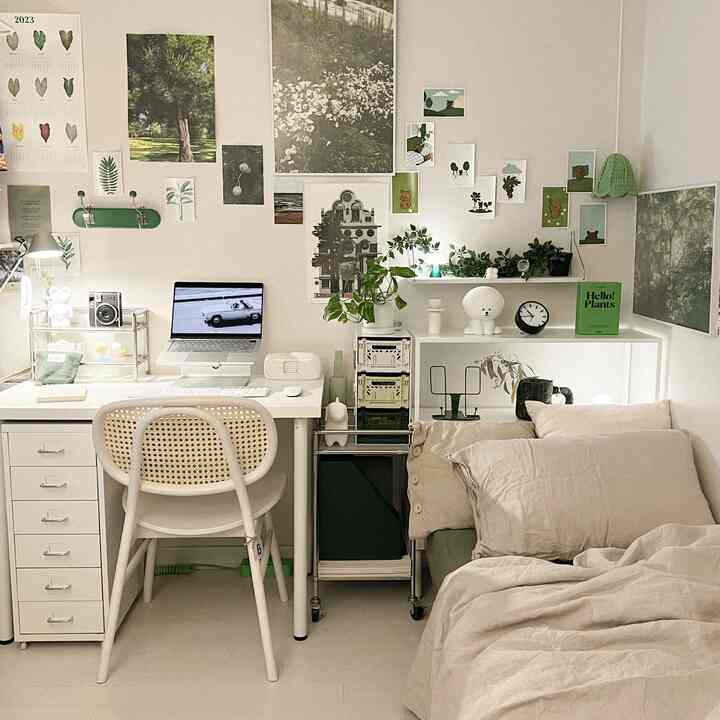 Natural-toned small bedroom and home office space featuring white furniture and green plants with a clean layout