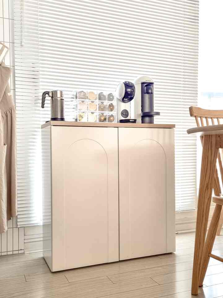 White and wood tone small kitchen home cafe space featuring neat cabinet and coffee machine for cozy atmosphere