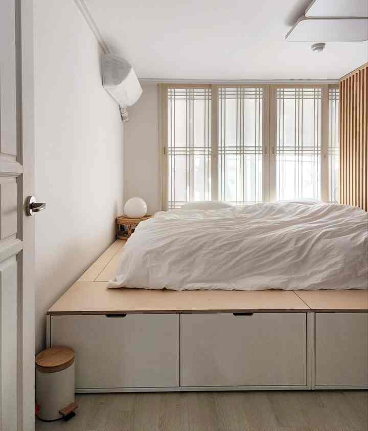 白とベージュの色調の寝室、広い収納スペースと自然光が調和した清潔感のあるインテリア