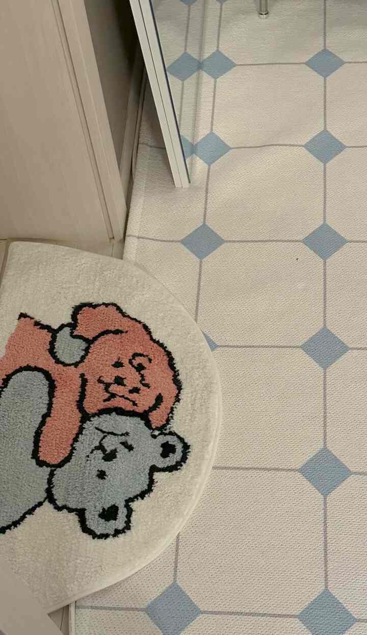Beige and blue entrance floor featuring a soft bear-patterned mat and modern patterned carpet, creating a cozy space