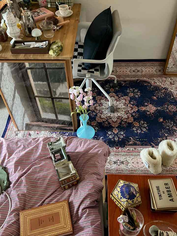 Natural tone bedroom featuring wooden desk, office chair, and Persian style rug creating cozy atmosphere