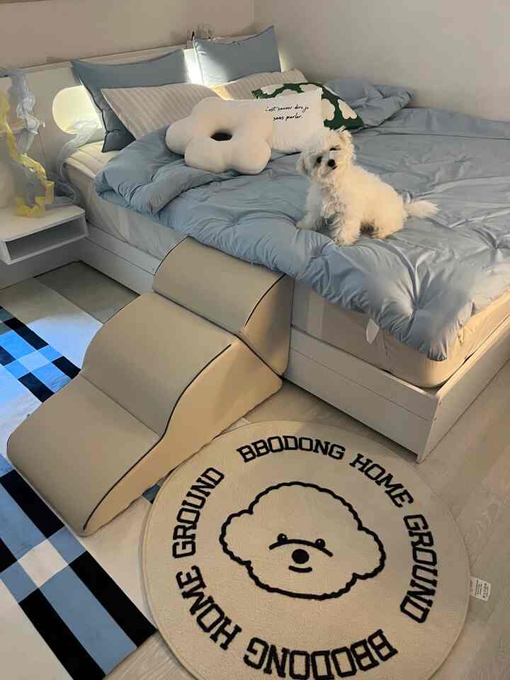 パステルブルーの寝室、白いベッドとペット用ステップ、犬のイラストラグが配置された印象的な空間