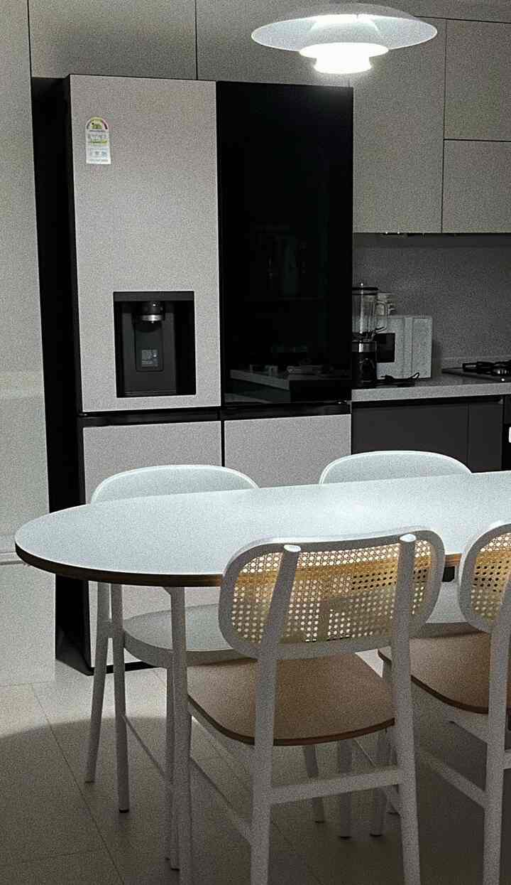 Modern kitchen in white and beige tones featuring rattan chairs and a simple dining table creating a clean atmosphere