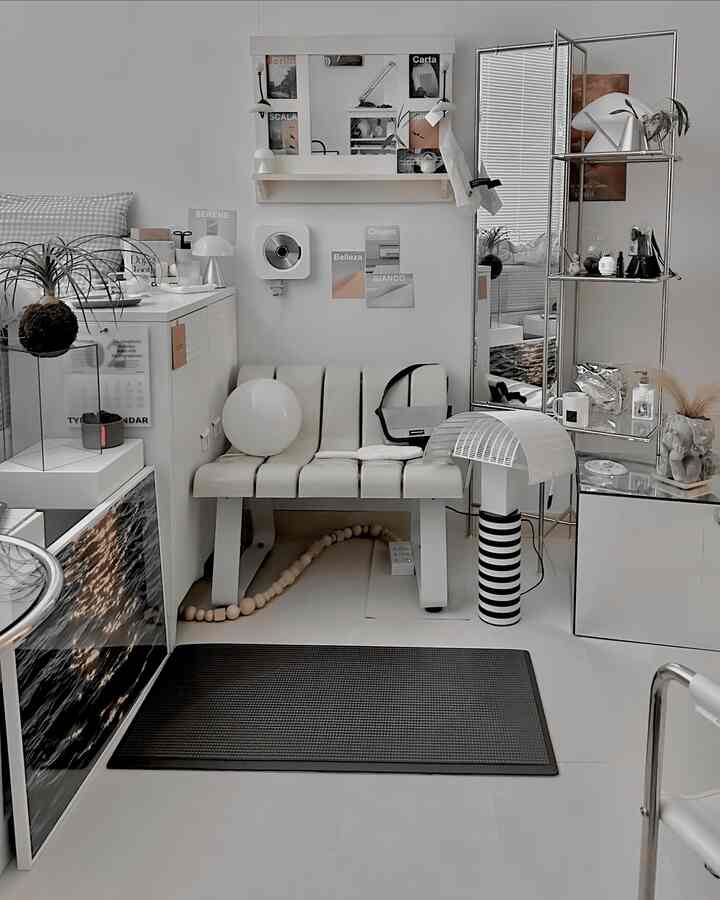 Bright white and silver toned indoor space featuring a bench, full-length mirror, and posters in a sleek modern style room
