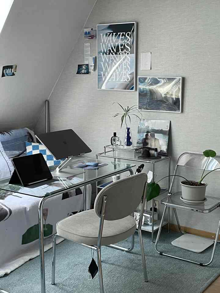 ブルーとホワイトのトーンでまとめられたミッドセンチュリーモダンのホームオフィス、透明な家具と植物が配置された清潔で実用的な空間