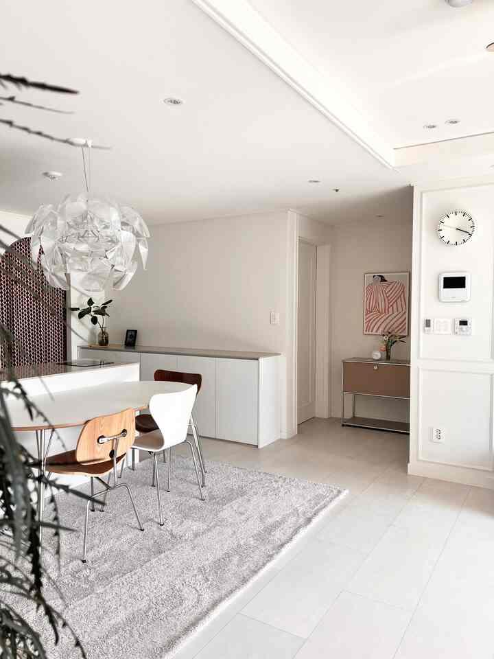 Minimal dining room for two-person household in white and natural tones, featuring pendant light as centerpiece