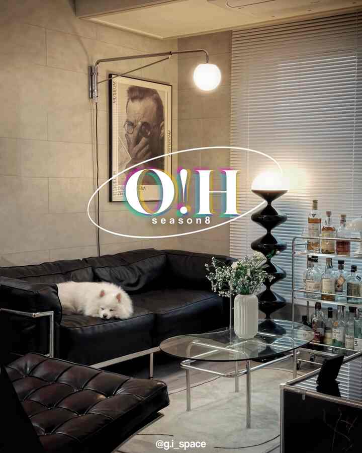 Black and white toned living room featuring mid-century modern sofa and bar cart, creating a sleek atmosphere