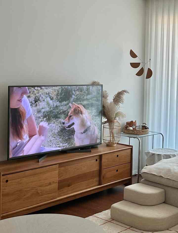 Bright modern living room with natural wood tones and beige furniture arranged neatly