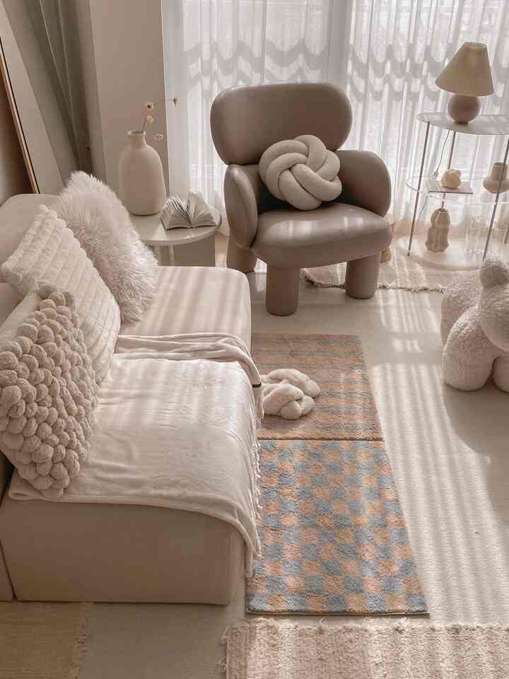 Beige and ivory toned living room featuring sofa and armchair with natural modern style interior