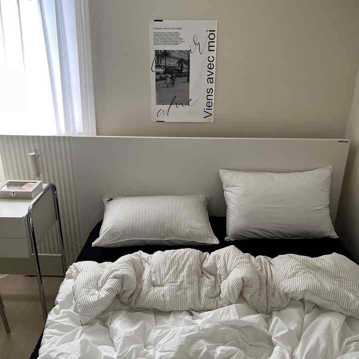 Monotone bedroom in white and black, featuring a simple modern bed with striped bedding