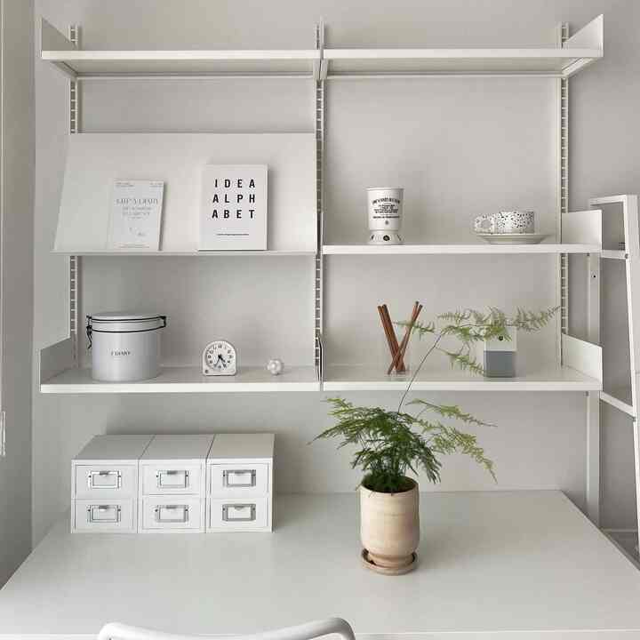 白を基調としたシンプルなホームオフィス、デスク上に植物とミニチェストが配置された整ったインテリア
