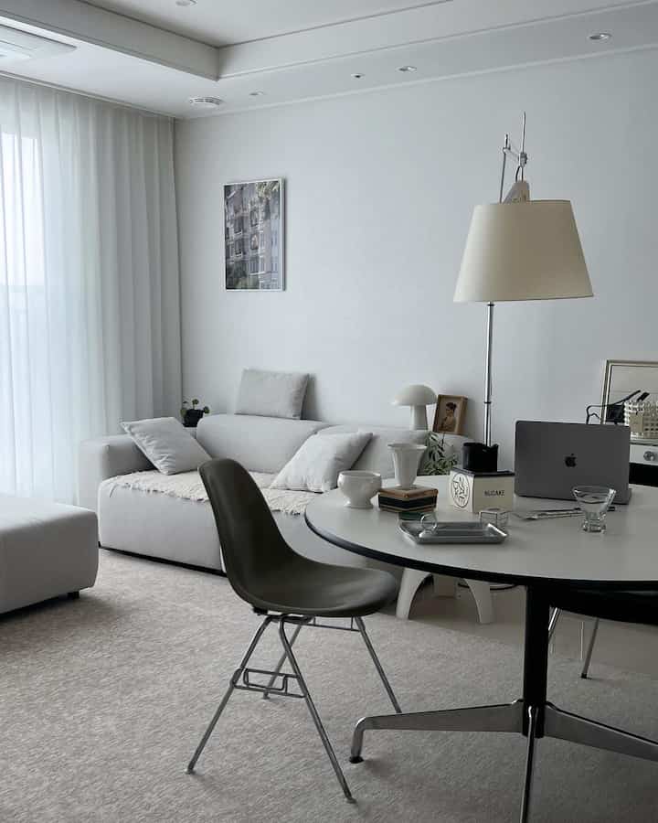 Bright white and gray toned living room featuring a round table and sofa with a modern, natural atmosphere
