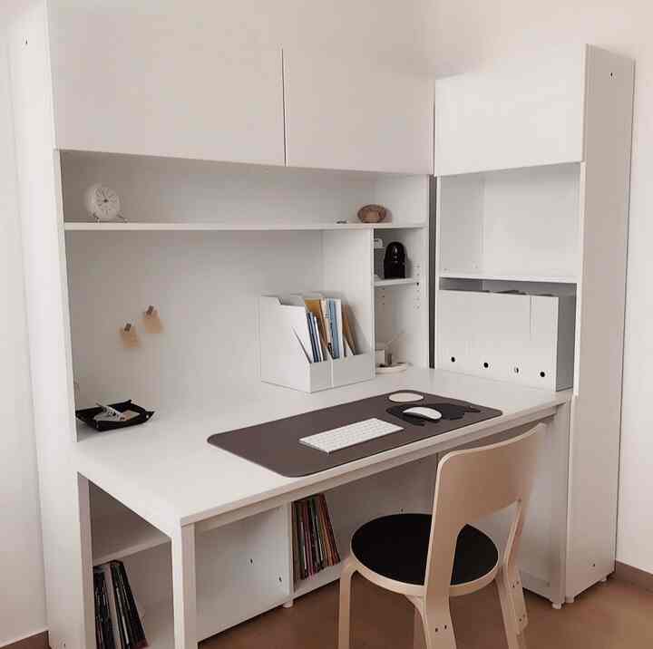 Natural modern kids' room with white and wood tones featuring a simple desk and storage units