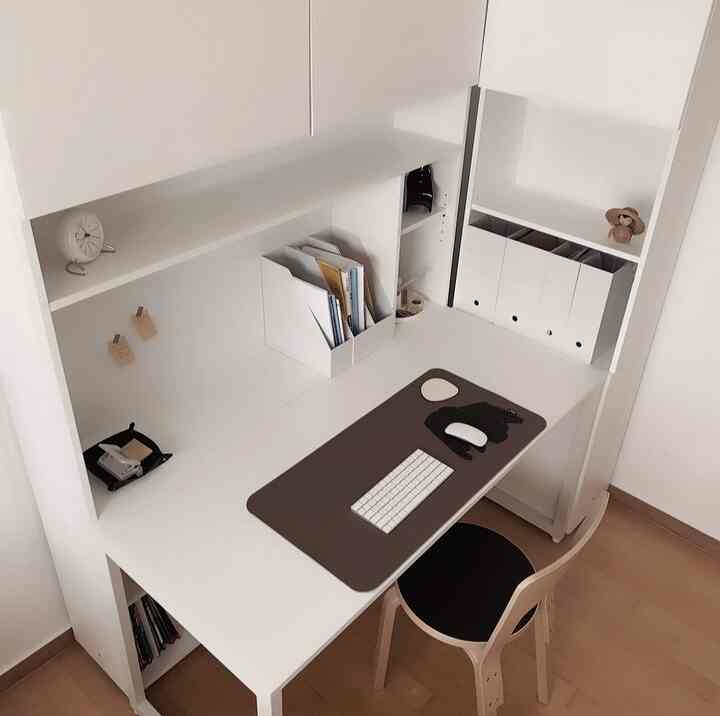 Small home office space in white and light brown tones featuring a tidy desk and storage with a modern minimalist atmosphere