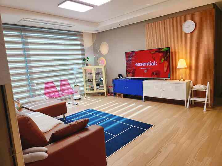 Mid-Century Modern living room with brown leather sofa and blue rug, featuring pet-friendly elements for living with a cat