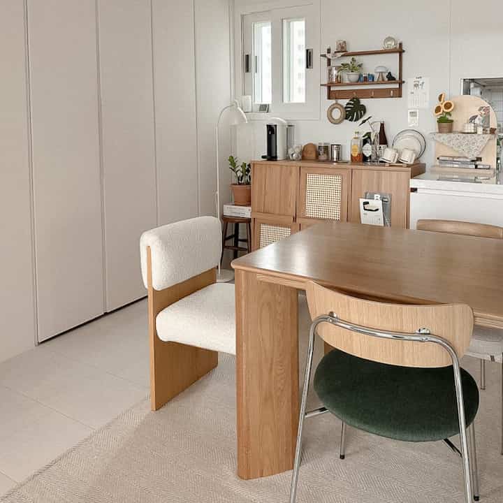 Cozy home cafe dining area with white walls and warm wood tone furniture