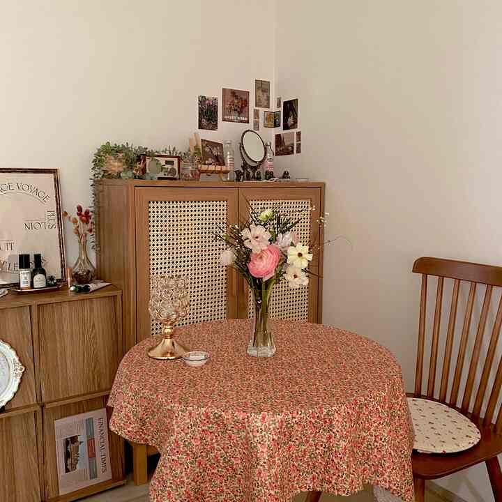 ヴィンテージな木目調家具と花柄のテーブルクロスが配置されたダイニング、温かみのある自然な雰囲気のインテリア