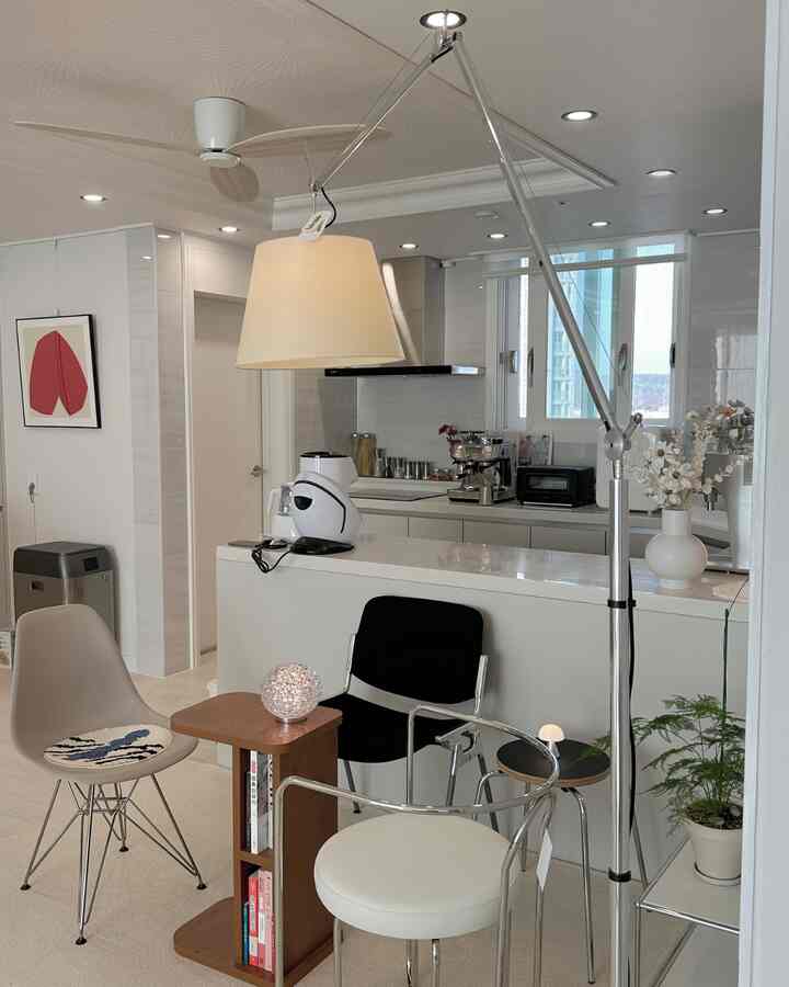 Bright and clean white and natural tone kitchen and living space featuring coffee equipment and modern furniture