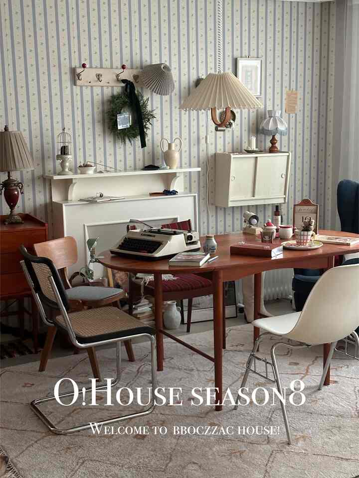 ベージュと木目調が調和したヴィンテージ風リビング、ミッドセンチュリーモダンのテーブルと椅子、パターン壁紙が温かみのある雰囲気を醸し出すインテリア