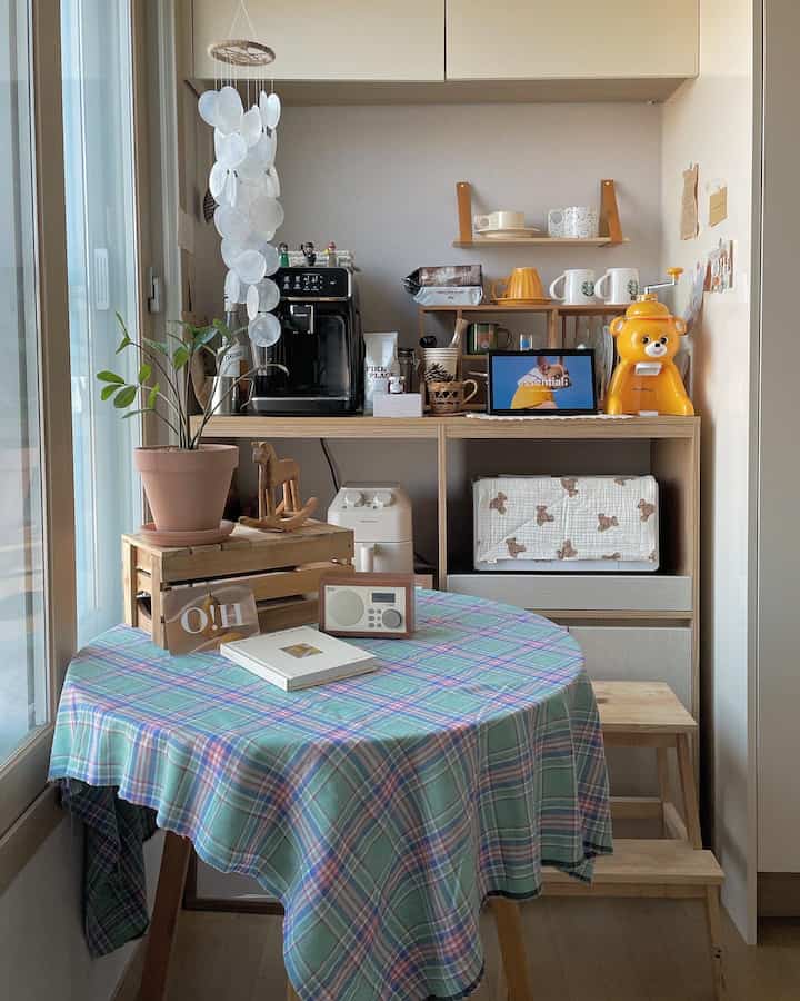 Natural wood tone kitchen featuring home cafe equipment and plaid tablecloth, creating a cozy atmosphere