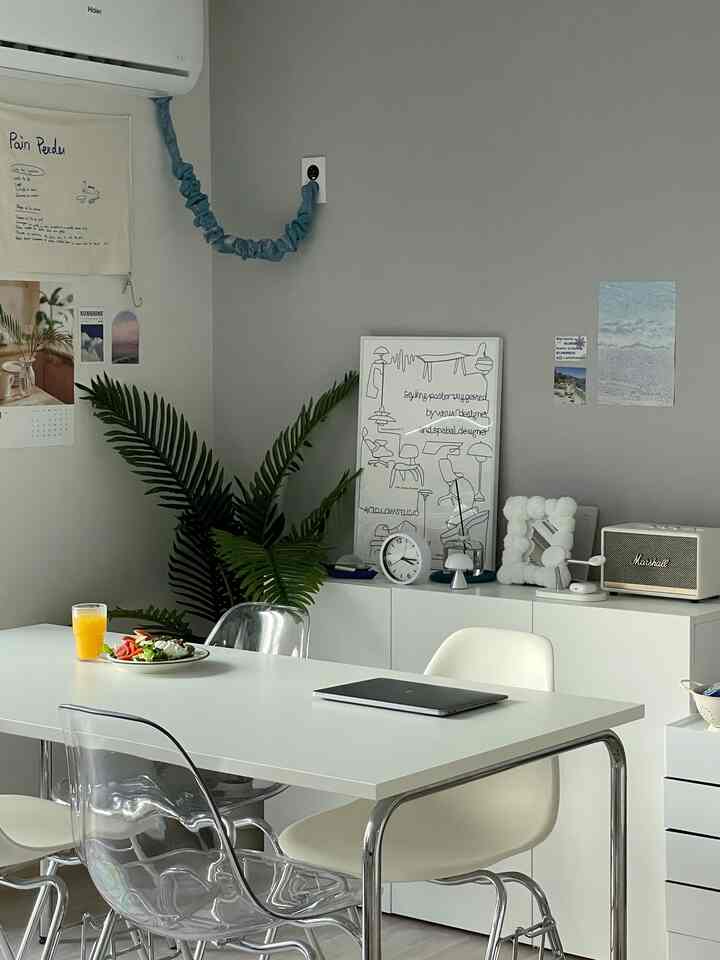 白とグレーの色調のキッチン、ミッドセンチュリーモダンのダイニングテーブルと椅子が配置された雰囲気のあるインテリア