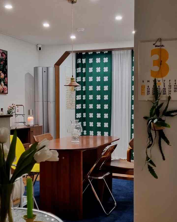 ブラウンとネイビートーンのダイニングルーム、木製テーブルと多様な椅子が配置された雰囲気のある空間