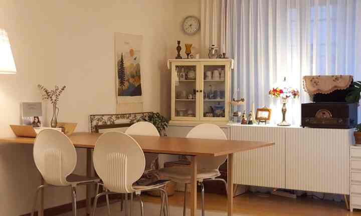 White and wood tone living room featuring dining table, chairs, and cozy lighting for a spring interior