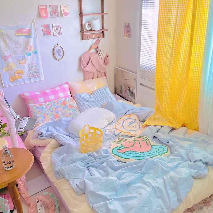 Pastel-toned kids' bedroom featuring a yellow checkered curtain, colorful pillows, and picture frames creating a cozy atmosphere.