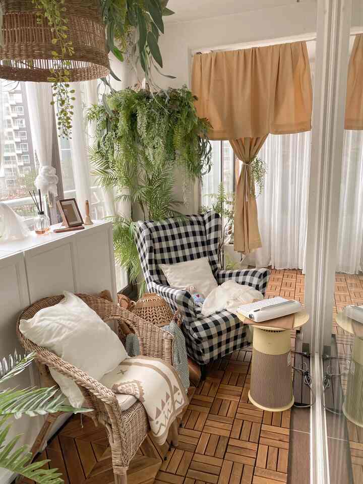 Yellow and wood-toned long narrow veranda featuring rattan chair and checkered sofa in a natural, cozy setting
