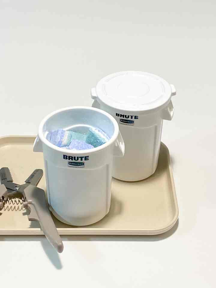 ホワイトとベージュのトレイに二つのプラスチック容器とナイフが整然と配置された、清潔感のあるキッチンの印象的な空間