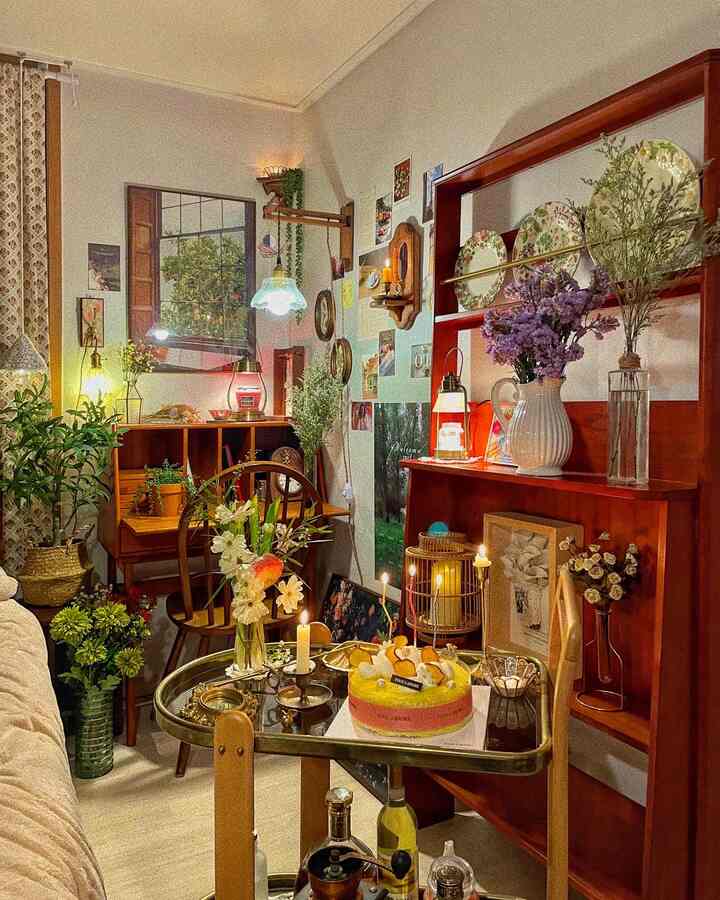 暖かい木目調のヴィンテージ寝室、ホテルライクな雰囲気のトロリーに誕生日ケーキが置かれた印象的な空間