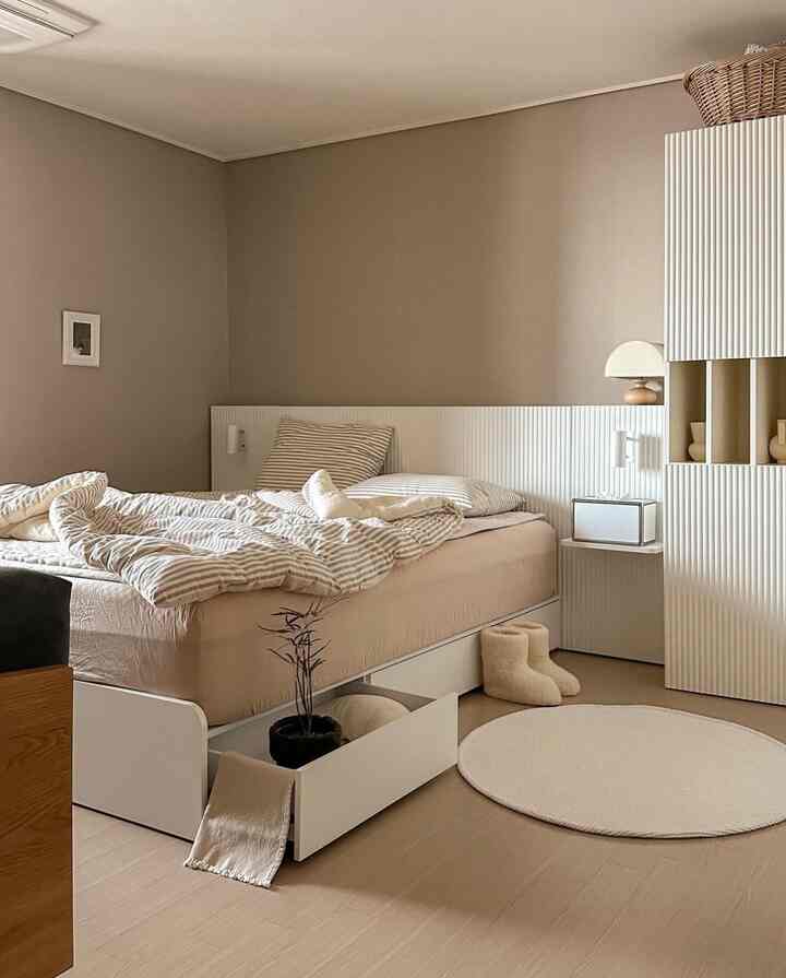 Natural color and white toned bedroom featuring a simple modern bed with storage and a round rug in a cozy atmosphere