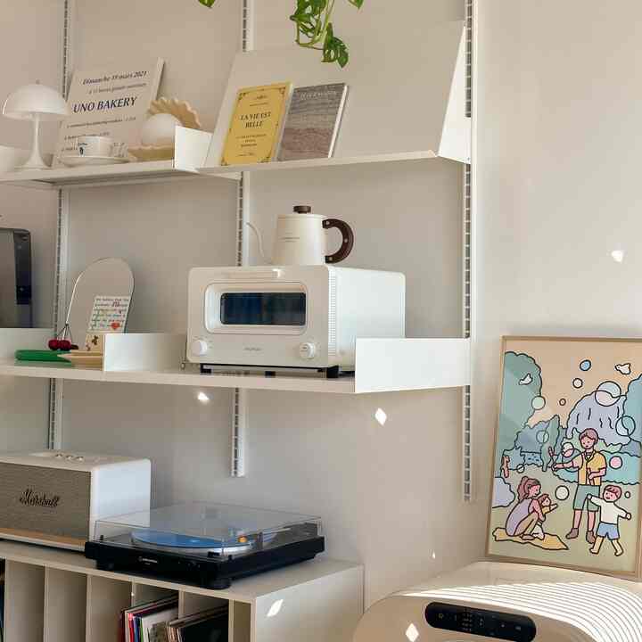 白とナチュラルトーンの棚とバルミューダのトースターが配置されたシンプルでモダンなキッチンスペース