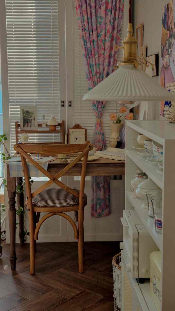 Warm brown wood-tone dining room featuring floral curtains, wooden dining table and chairs arranged centrally